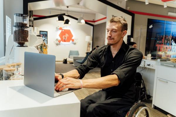 Un hombre en silla de ruedas trabaja con un ordenador