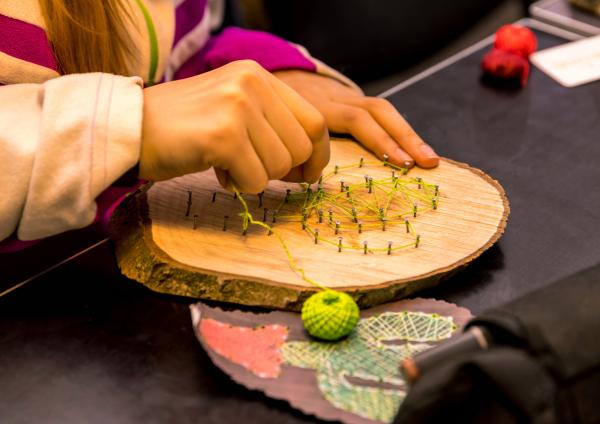 Una persona practicando 'string art'