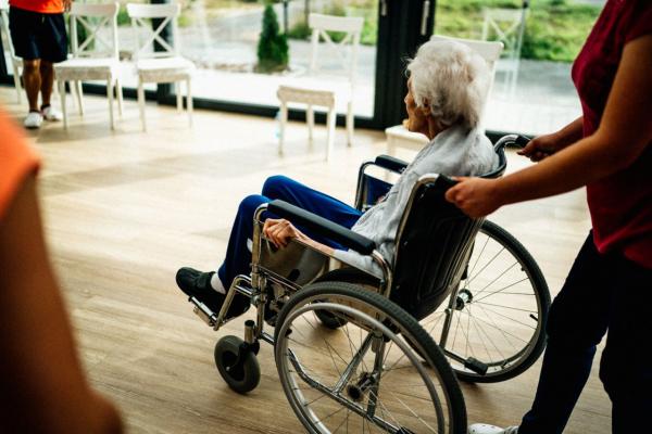 Una persona empuja la silla de una usuaria