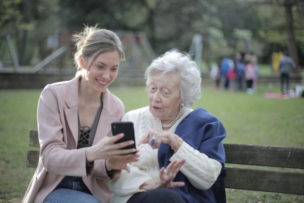 Una mujer enseña una imagen de móvil a una anciana